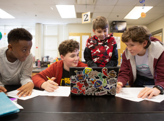 Sixth-graders work together on a science project about weather disasters.