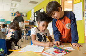 First-Grade Boy Helps Girl Classmate with Assignment